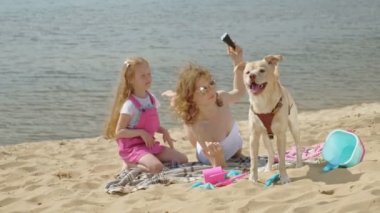 Nehir kıyısındaki anne ve kızı dondurma yiyor. Açık hava rekreasyon