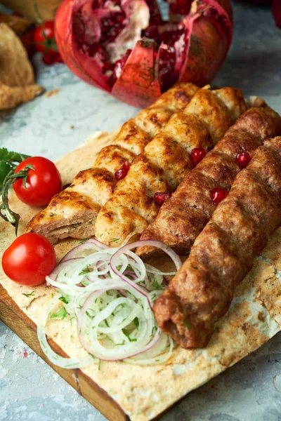Gri arka planda barbekü ve kebap ile et tabakları