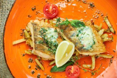 bir tabakta sebze ve patates ile kızarmış balık