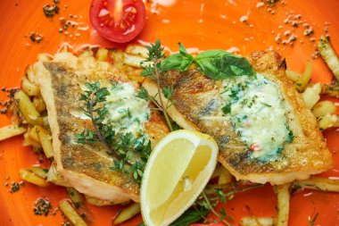 bir tabakta sebze ve patates ile kızarmış balık