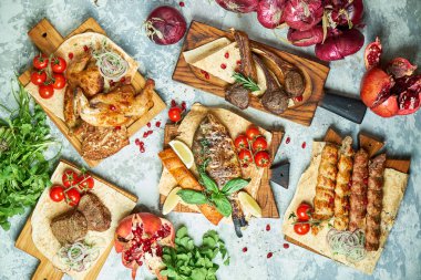 Barbekü ve kebap ile et tabakları, gri arka plan üzerinde üst görünümü