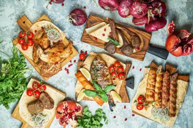 Barbekü ve kebap ile et tabakları, gri arka plan üzerinde üst görünümü