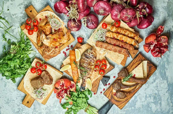 Plates of meat with barbecue and kebab, top view on gray background — Stock Photo, Image