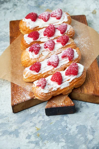 Cake eclair. Sfondo grigio strutturato. Bellissimi piatti di servizio. Dolce. Catena alimentare — Foto Stock