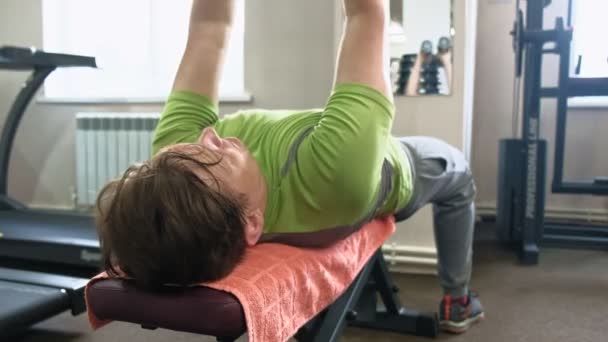 Man doet Bench Press in fitness studio — Stockvideo