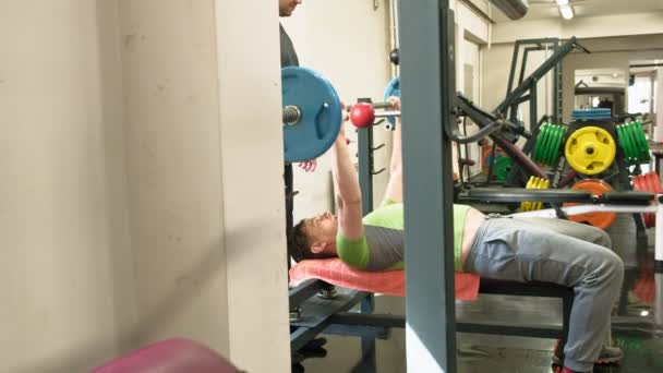 Man doet Bench Press in fitness studio — Stockvideo