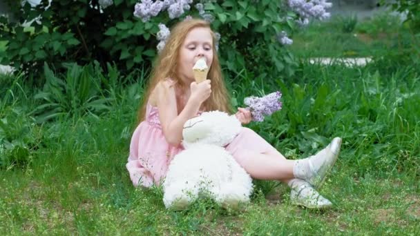 어린 소녀는 야외에서 아이스크림을 먹는다. 여름 — 비디오