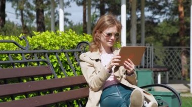 Genç bir kadın bilgisayar tableti kullanıyor. Uzak iş kavramı