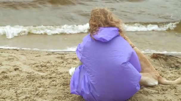 Jeune femme avec un chien sur la plage au bord de la rivière — Video