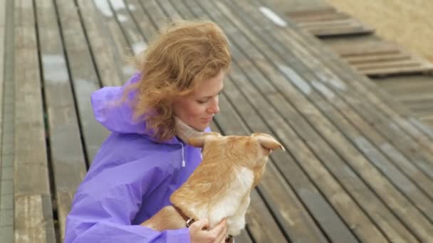 Ung kvinna med hund på stranden vid floden — Stockvideo