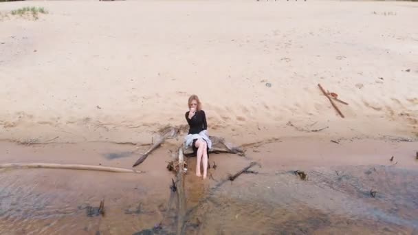 Una joven con un vestido corre por la playa. Disparo aéreo — Vídeo de stock