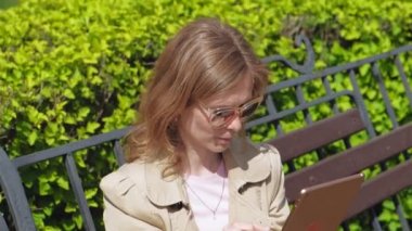 Genç bir kadın bilgisayar tableti kullanıyor. Uzak iş kavramı