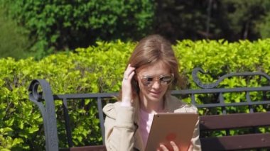 Genç bir kadın bilgisayar tableti kullanıyor. Uzak iş kavramı