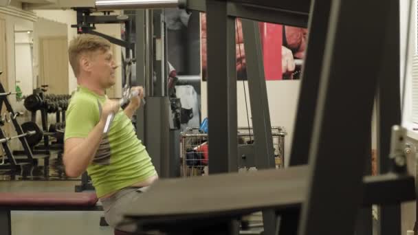 El hombre con sobrepeso comparte el bloque superior del gimnasio. Fitness. Estilo de vida saludable . — Vídeos de Stock