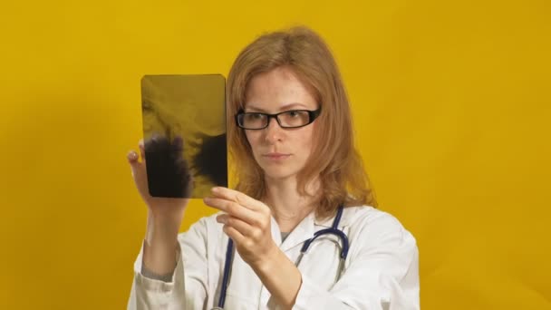 Uma jovem doutora. Fundo amarelo. O conceito de medicina . — Vídeo de Stock