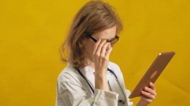 Genç bayan doktor. Sarı arka plan. Tıp konsepti.
