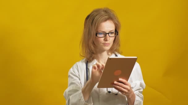 Jonge vrouwelijke dokter. Gele achtergrond. Het begrip "geneeskunde". — Stockvideo