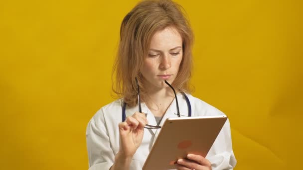 Fiatal doktornő. Sárga háttér. Az orvostudomány fogalma. — Stock videók