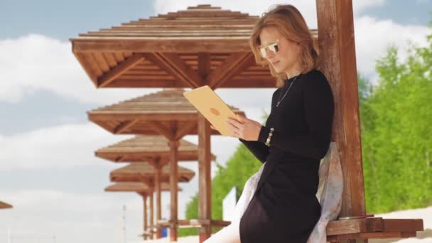 Μια νεαρή γυναίκα χρησιμοποιεί μια ταμπλέτα. Ιδέα για απομακρυσμένες επιχειρήσεις — Αρχείο Βίντεο