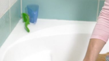 Kadın banyoda bir köpeği yıkıyor. Hayvan bakımı