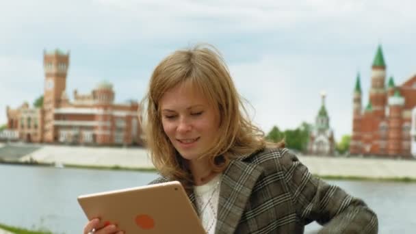 Woman uses tablet outdoors. Spring — Stock Video