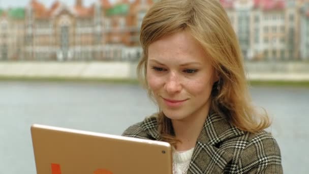 Mujer utiliza tableta al aire libre. Primavera — Vídeos de Stock