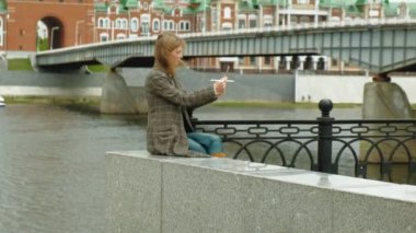 Kadın açık havada tablet kullanıyor. Bahar