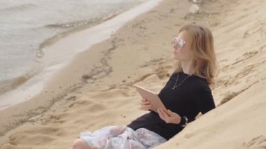 Genç bir kadın tablet kullanıyor. Uzak iş kavramı