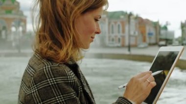 Kadın açık havada tablet kullanıyor. Bahar