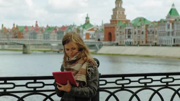 Mulher usa tablet ao ar livre. Primavera — Vídeo de Stock
