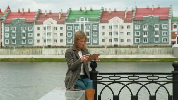 Mujer utiliza tableta al aire libre. Primavera — Vídeos de Stock