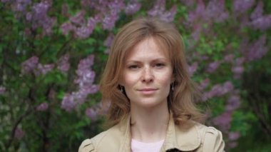 Leylak çalılarının arkasında genç bir kadın.