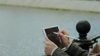 Kadın açık havada tablet kullanıyor. Bahar
