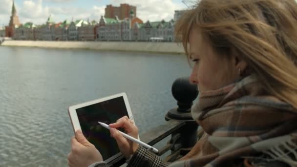 Mujer utiliza tableta al aire libre. Primavera — Vídeo de stock