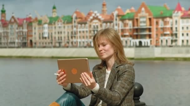 Kvinna använder tablett utomhus. Våren — Stockvideo