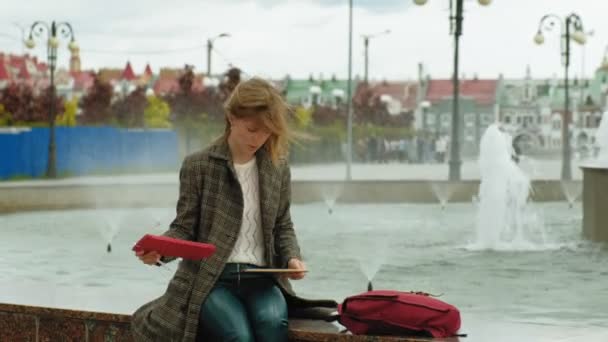 Mujer utiliza tableta al aire libre. Primavera — Vídeos de Stock