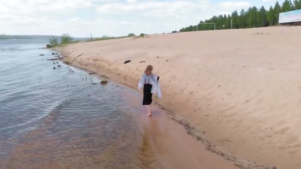 Mladá žena v šatech vede po pláži. Letecká výstřela — Stock video