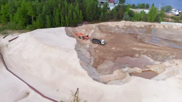 Pedreira de areia. Escavadora de trabalho e caminhão basculante. Tiro aéreo — Vídeo de Stock