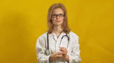 Genç bayan doktor. Sarı arka plan. Tıp konsepti.