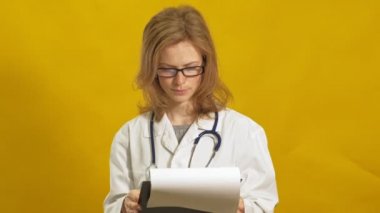 Genç bayan doktor. Sarı arka plan. Tıp konsepti.