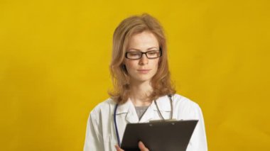 Genç bayan doktor. Sarı arka plan. Tıp konsepti.