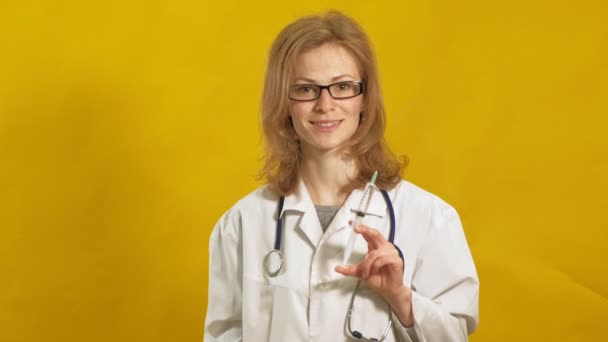 Jonge vrouwelijke dokter. Gele achtergrond. Het begrip "geneeskunde". — Stockvideo