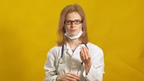 Jonge vrouwelijke dokter. Gele achtergrond. Het begrip "geneeskunde". — Stockvideo
