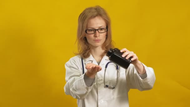 Jonge vrouwelijke dokter. Gele achtergrond. Het begrip "geneeskunde". — Stockvideo