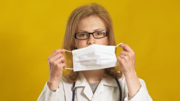 Jonge vrouwelijke dokter. Gele achtergrond. Het begrip "geneeskunde". — Stockvideo