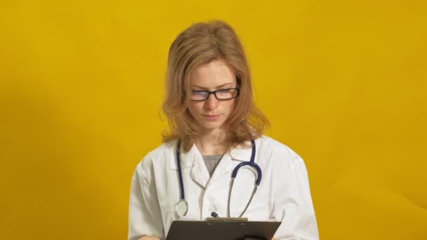 Una joven doctora. Fondo amarillo. El concepto de medicina . — Vídeos de Stock