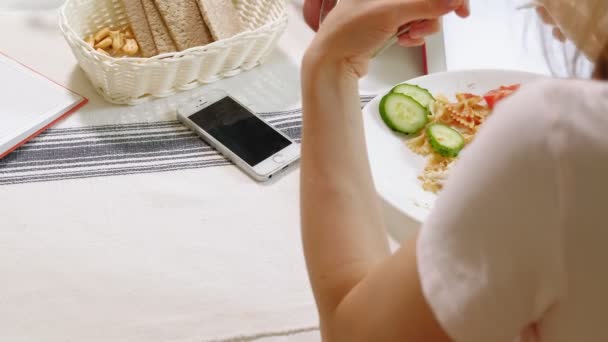 Vrouw met een hond in de keuken aan tafel. Ontbijt. Vriendschap van mens en huisdier. — Stockvideo