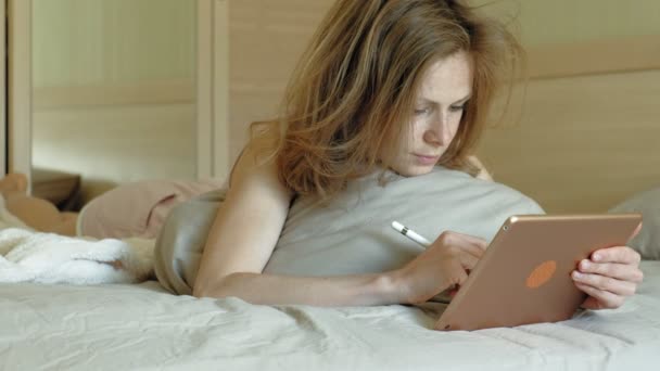 Mujer en la cama usando una tableta de computadora. Buenos días. — Vídeos de Stock