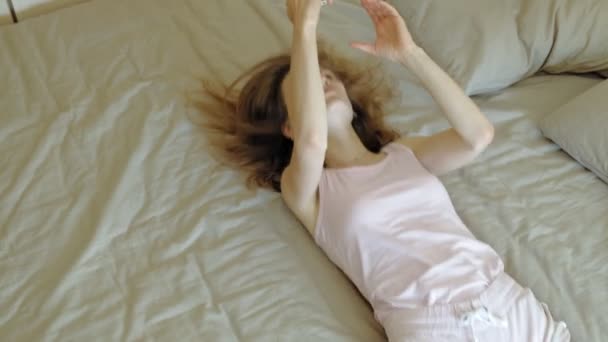 朝。ベッドで女性を目覚めさせる. — ストック動画