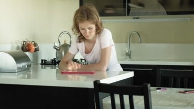 Mutfaktaki kadın tableti kullanıyor, sadece uyandım. Kahvaltı. Sabah erken saatlerde